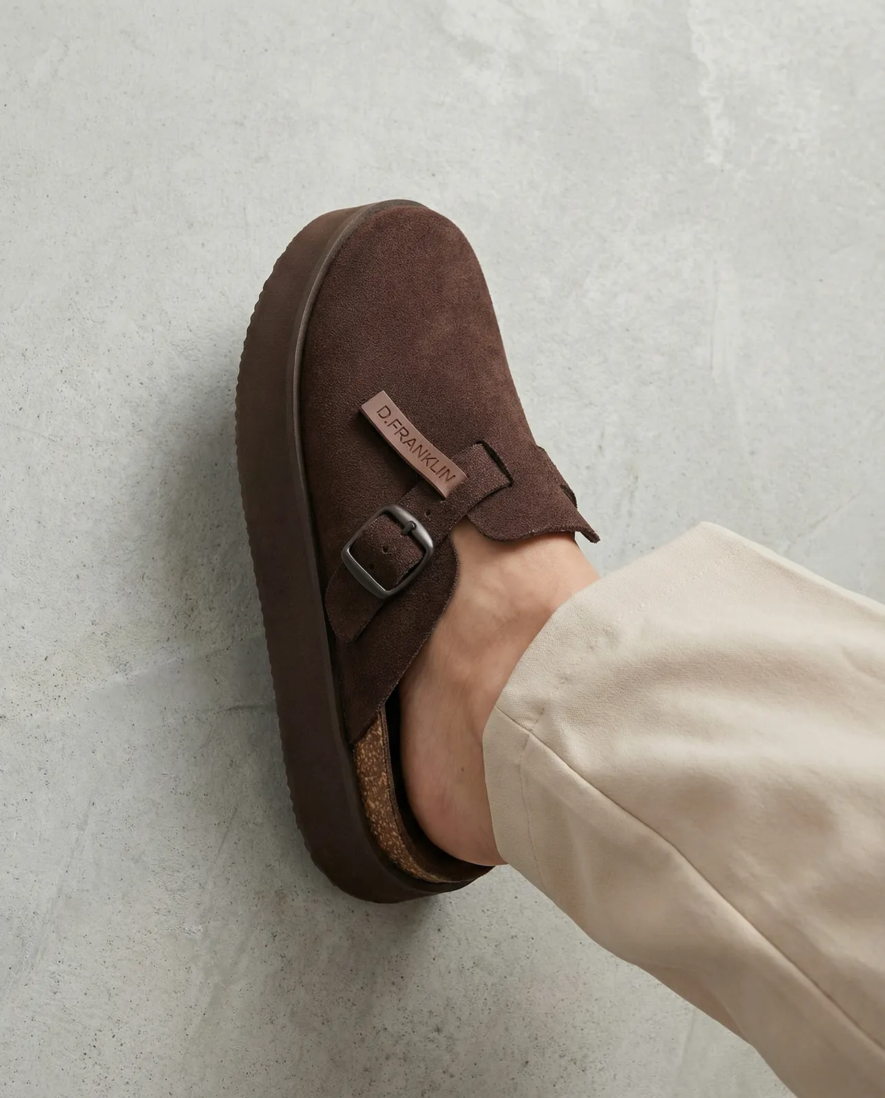 Detalle del zueco de ante marrón DFranklin, foto lifestyle IA